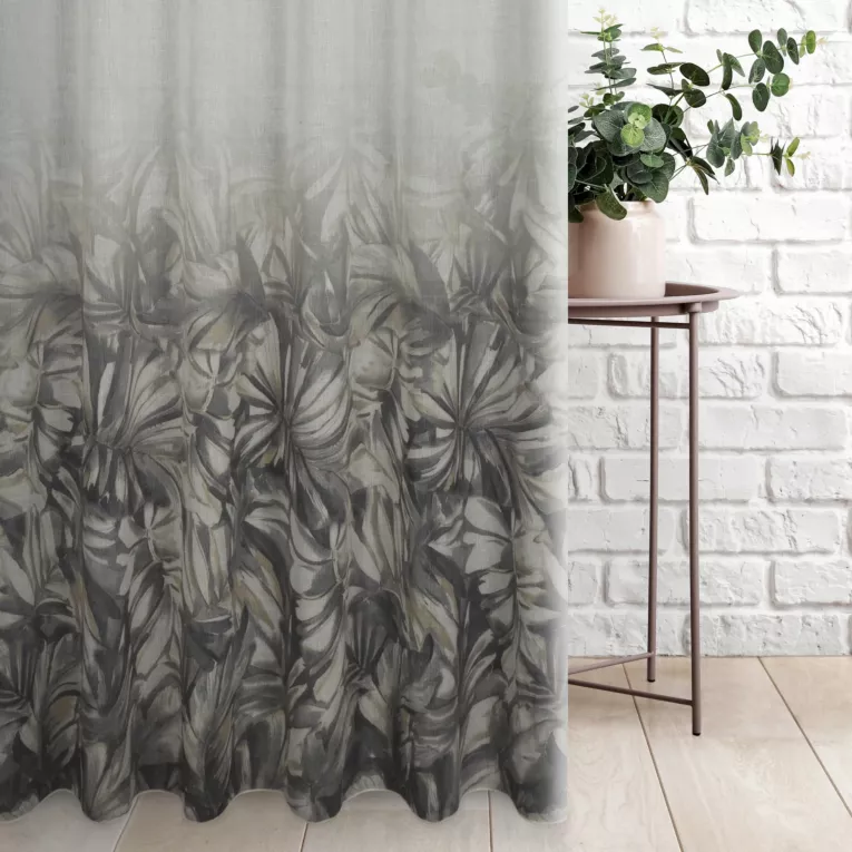 Firana szyta na taśmie fala kremowo popielata z miękkiej tkaniny o naturalnym splocie, z malarskim nadrukiem liści, wykończona obciażnikiem