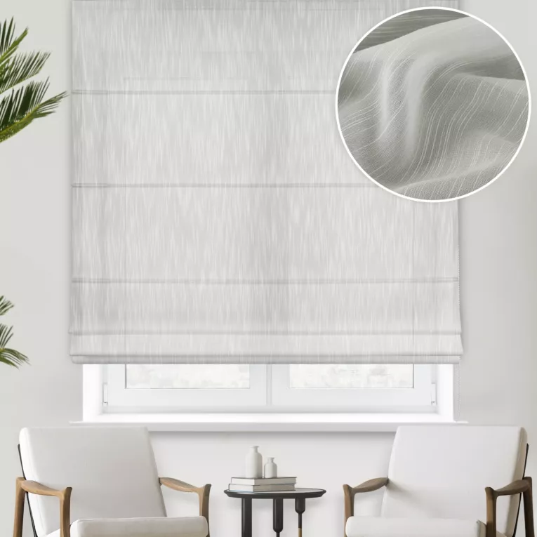 Roleta rzymska kremowa z delikantej, lejącej tkaniny z efektem deszczyku w postaci pionowych, nieregularnych linii, wykończona obciążnikiem