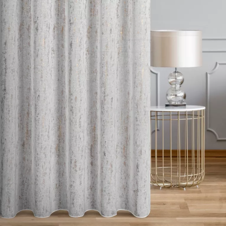 Firana szyta na flexach naturalno złota z matowej etaminy ozdobionej nieregularnym, połyskliwym nadrukiem, wykonczona obciążnikiem Italissima Eva Minge