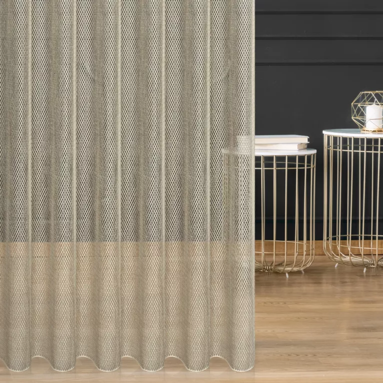 Firana szyta na przelotkach beżowa z siatki tkanej w drobny wzór, przetykanej błyszczącą nicią, wykończona obciążnikiem Italissima Eva Minge