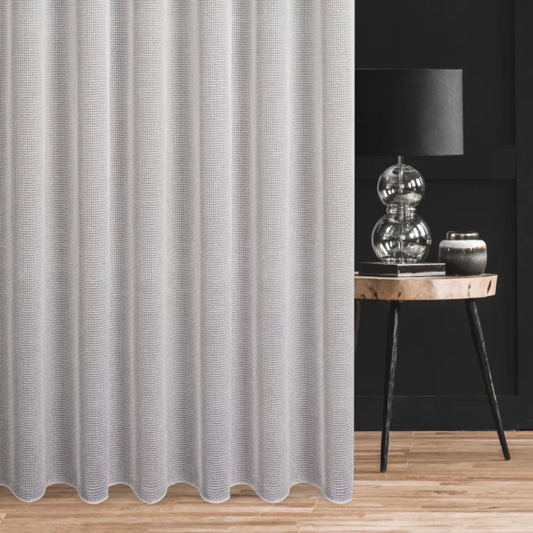 Firana szyta na przelotkach kremowo złocista z siatki o geometrycznym splocie z błysczącą nicią, wykończona obciążnikiem