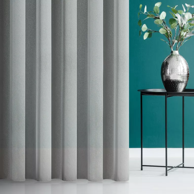 Firana szyta na tunelu srebrna z miękkiej i połyskliwej tkaniny, wykończona obciążnikiem