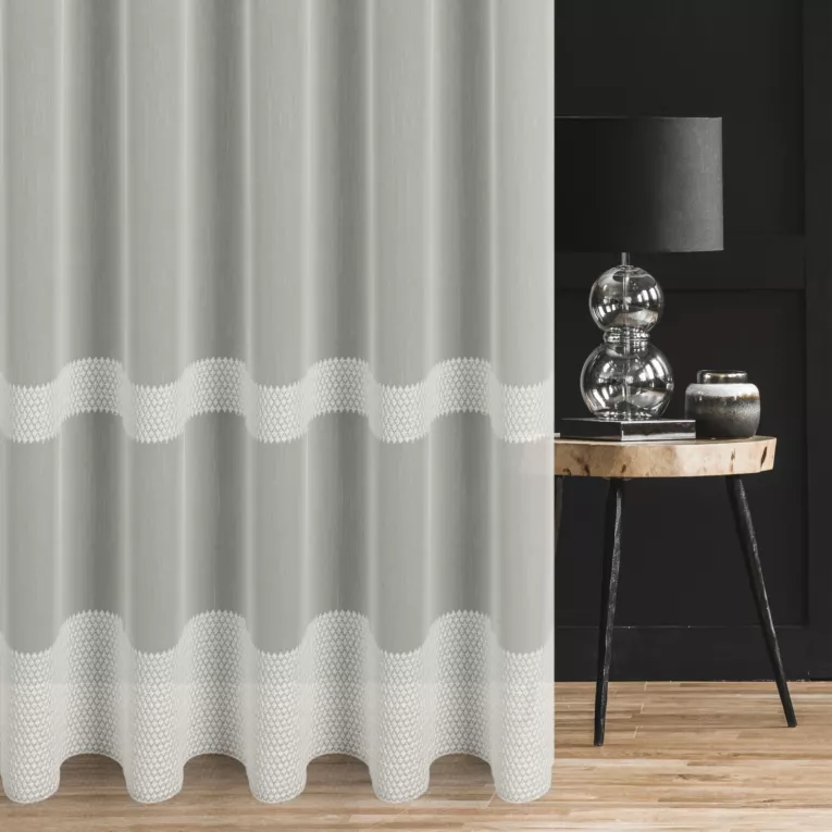 Firana szyta na tunelu kremowa z tkaniny typu Aden, zdobiona drobnym, geometrycznym haftem tworzącym poziome pasy