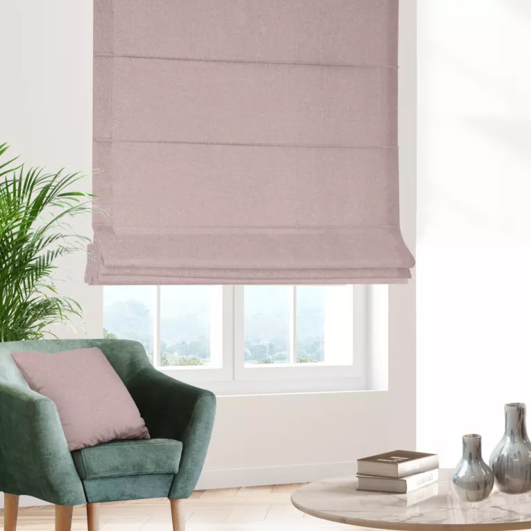 Roleta rzymska pudrowo różowa o naturalnym charakterze, z widocznym, ozdobnym splotem