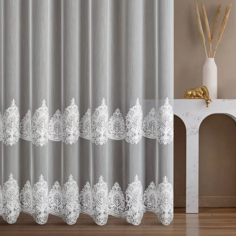 Firana szyta na flexach biała z tkaniny typu aden z efektem delikatnego deszczyku, zdobionej haftem łańcuszkowym we wzór ornamentowy