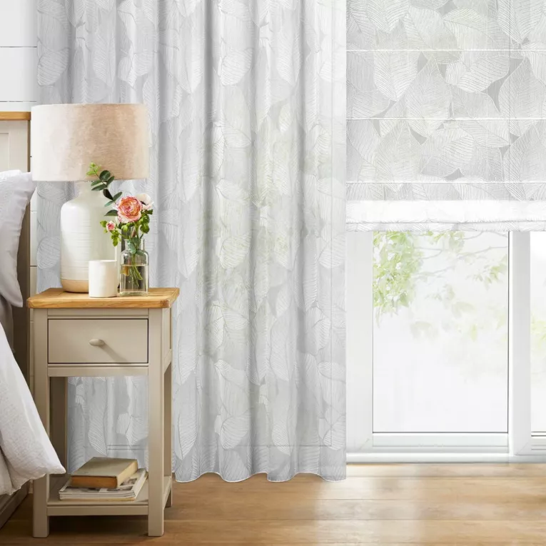 Roleta rzymska biało srebrna z tkaniny typu BATYST z delikatnie połyskującym nadrukiem w kształcie liści po całości tkaniny, wykończona obciążnikiem