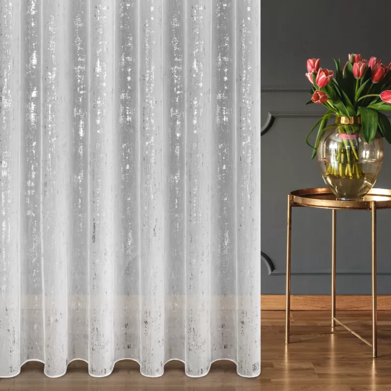 Firana szyta na przelotkach biało srebrna z tkaniny typu ADEN z efektem deszczyku, zdobionej niereguralnym srebrnym nadrukiem, wykończona obciążnikiem