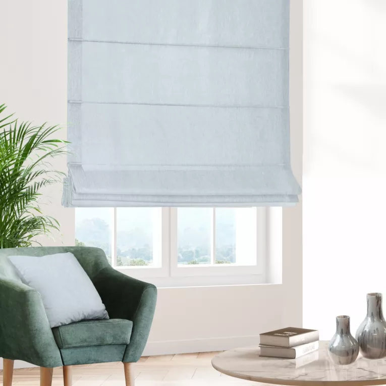 Roleta rzymska błękitno jasnoszara z półprzezroczystej tkaniny o wyglądzie drobnego deszczyku i delikatnym połysku, wykończona obciążnikiem