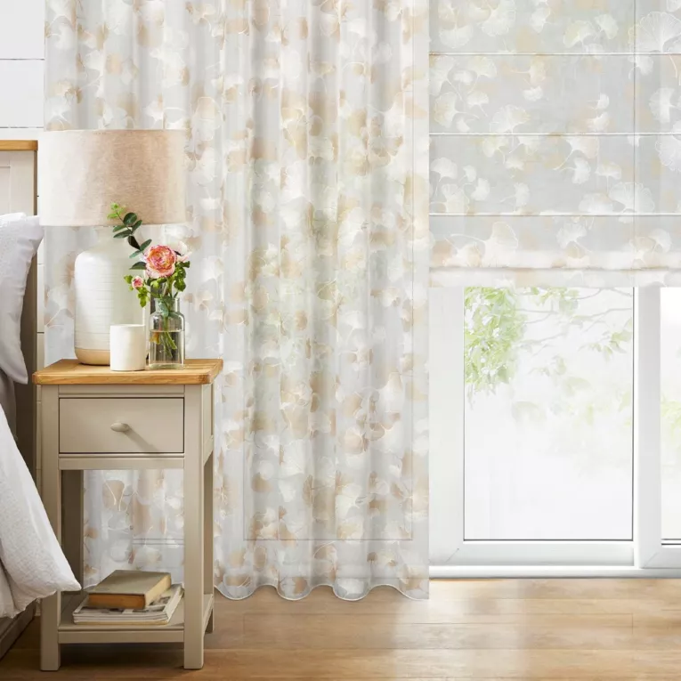 Roleta rzymska biało złota z tkaniny typu ETAMINA z delikatnie połyskującym, botanicznym nadrukiem na całości tkaniny, wykończona obciążnikiem