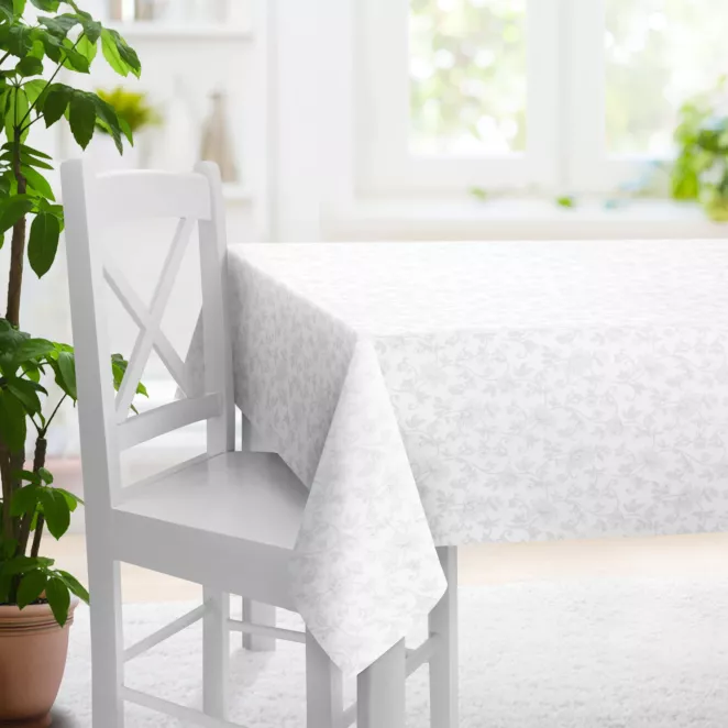 Obrus szyty biało srebrny z gładkiej tkaniny przeplatanej błyszczącą lureksową nicią o wzorze w kwiaty