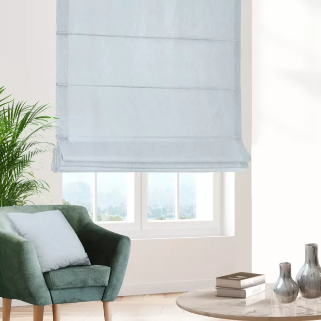 Roleta rzymska błękitno jasnoszara z półprzezroczystej tkaniny o wyglądzie drobnego deszczyku i delikatnym połysku, wykończona obciążnikiem