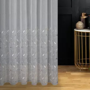 Firana szyta na tunelu kremowo beżowa z matowej etaminy haftowanej w roślinny wzór z połyskującą nicią, wykończona obciążnikiem