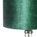 Lampa stołowa do pokoju ciemnozielona KIM na podstawie z przezroczystego szkła ze szmaragdowym abażurem z lśniącego welwetu Eurofirany
