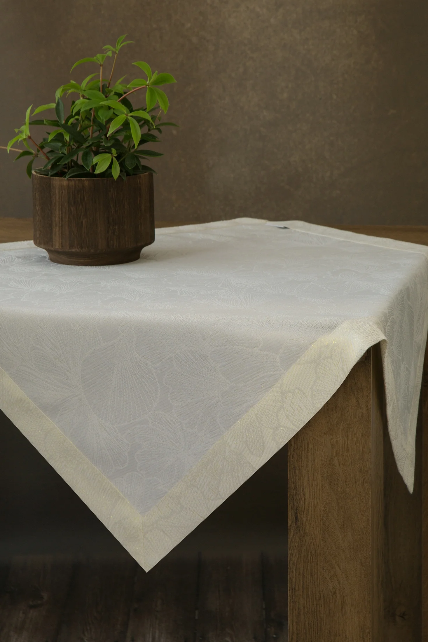 Bieżnik na stół kremowy 85x85 cm LILIAN z delikatnym wzorem liści z tkaniny przeplatanej złotą nicią z elegancką podwójną listwą